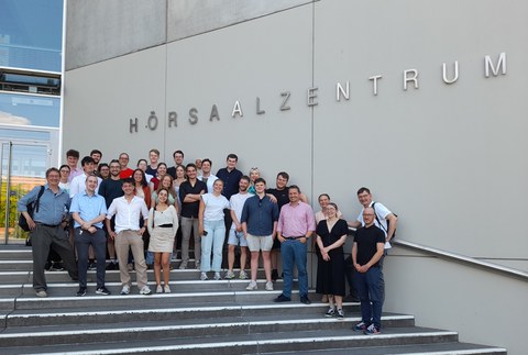 A group of mainly young people in front of the TU Dresden lecture hall center.