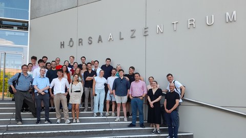 A group of mainly young people in front of the TU Dresden lecture hall center.