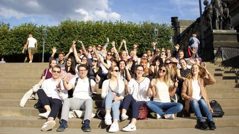 Gruppenfoto auf Treppe Brühlsche Terrasse, viele TeilnehmerInnen lachen und recken Hände in die Höhe, sonniges Wetter