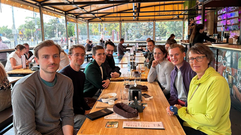 Das Team der Professur für Angwandte Linguistik an einem Tisch in einer Art Biergarten.