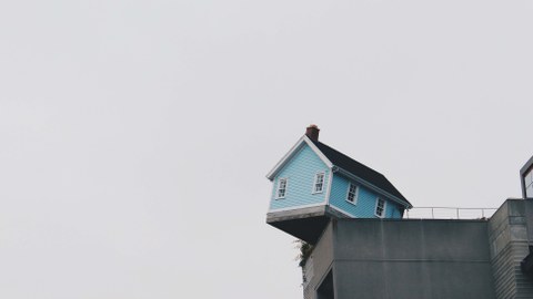 Ein Haus hängt halb über eine Klippe und droht zu fallen.
