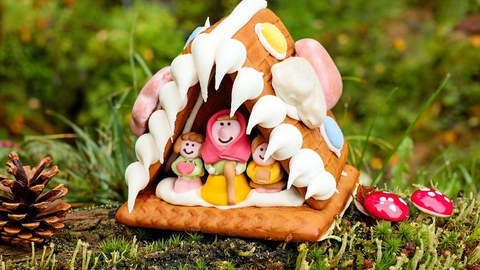 Lebkuchenhaus mit Figuren, symbolisiert die Geschichte von Hänsel und Gretel