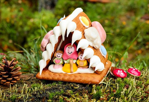 Lebkuchenhaus mit Figuren, symbolisiert die Geschichte von Hänsel und Gretel