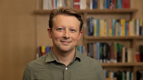 Philipp Lorenz-Spreen vor einem Bücherregal