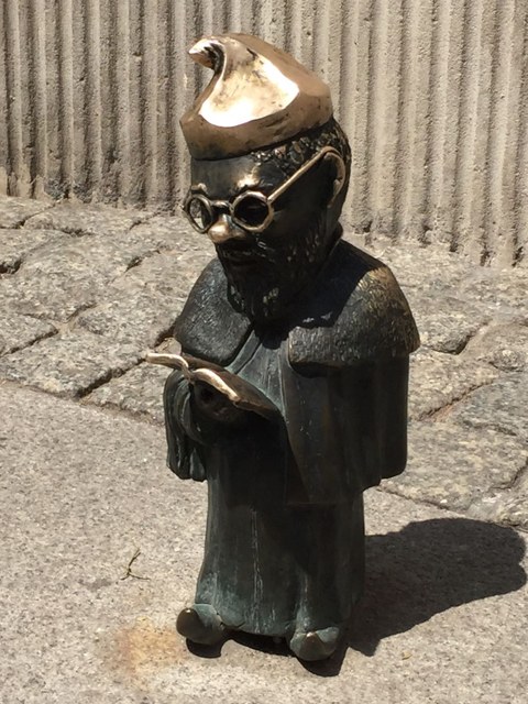 Bronzener Zwerg mit Brille, der ein Buch liest