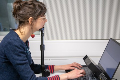 Eine junge Frau am Eyetracker, das Kinn in einer Stütze