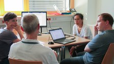Gruppenarbeit: Teilnehmende sitzen um einen Tisch