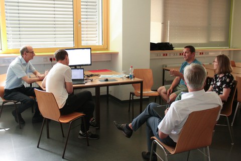 Gruppenarbeit: Eine Gruppe Teilnehmender um einen Tisch