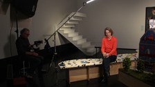 Das Bild zeigt Prof. Lauber-Rönsberg bei einem TUDiSC Drehtag im Hygienemuseum. Lauber-Rönsberg sitzt und trägt eine orangene Stoffjacke