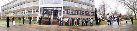 Panorama-Aufnahme vor dem Gebäude der Universitätsschule Dresden mit der Delegation für die Übergabe der Spenden und Unterschriftenlisten und Eltern mit ihren Kindern.