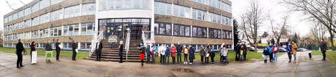 Panorama-Aufnahme vor dem Gebäude der Universitätsschule Dresden mit der Delegation für die Übergabe der Spenden und Unterschriftenlisten und Eltern mit ihren Kindern.