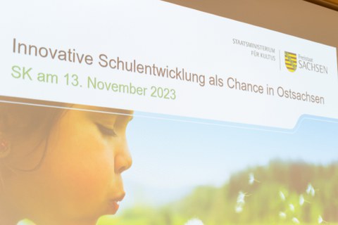 Foto von der Titelseite der Präsentation zur Auftaktveranstaltung zu "Schule bewegt Sachsen" in der Sächsischen Staatskanzlei am 13.11.2023 mit der Überschrift "Innovative Schulentwicklung als Chance in Ostsachsen"..   