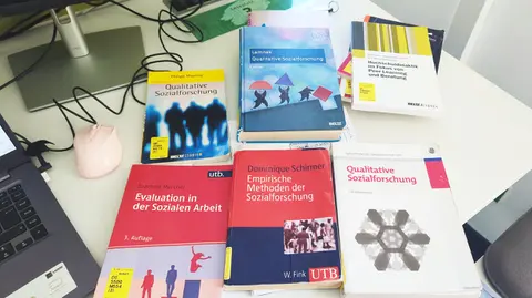 On a library desk lie various books on methods of empirical social research.