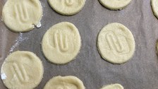 runde Kekse mit dem Logo der Universitätsschule Dresden liegen auf dem Backblech