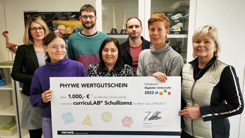 Vertreter:innen der Schülerschaft, des Fachlehrerkollegiums und Schulleiterin Maxi Heß nehmen den PHYWE-Schulpreis entgegen.