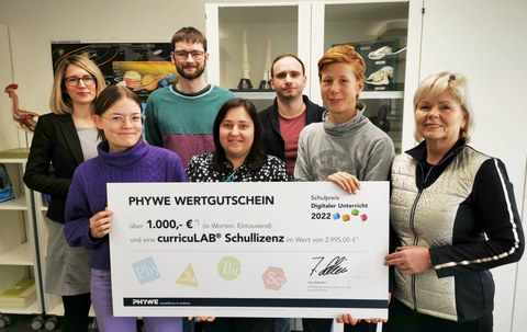 Vertreter:innen der Schülerschaft, des Fachlehrerkollegiums und Schulleiterin Maxi Heß nehmen den PHYWE-Schulpreis entgegen.