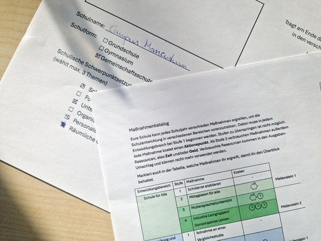 Ausgefülltes Arbeitsblatt mit einem Maßnahmenkatalog im Planspiel Schulentwicklung für die studentische Projektschule „campus momentum“ mit Texten und Tabellen