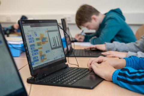 Kinder mit Laptop an der Universitätsschule Dresden