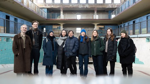 Gruppenbild mit sieben Personen in einem alten Schwimmbad
