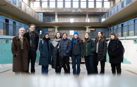 Gruppenbild mit sieben Personen in einem alten Schwimmbad