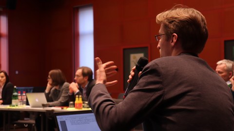 Felix Prautzsch stellt eine Frag während der Diskussion nach Prof. Dr. Anja Lobenstein-Reichmanns Vortrag 