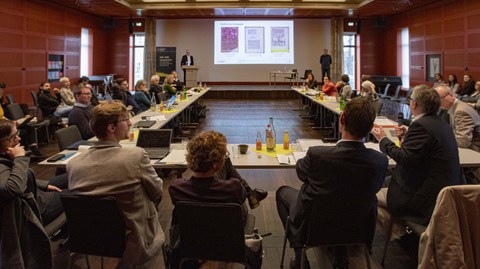 Rückansicht des Publikums während Prof. Dr. Jürgen Müller eine Frage stellt.