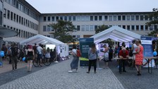 Blick in den Hof des Falkenbrunnen, zu sehen sind der Vortrags- und der Besucherpavillon mit Besuchern