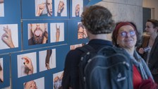 Foto von der Vernissage - Besucher betrachten Bilder an der Wand