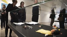 Foto von der Vernissage - Besucher betrachten eine Vitrine