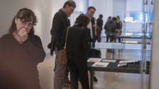 Foto von der Vernissage - Besucher betrachten eine Vitrine