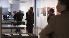 Foto von der Vernissage - Besucher betrachten eine Vitrine
