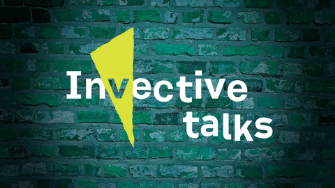 Logo "Invective Talks" im Stil des SFB-Logos, im Spotlight vor grüner Backsteinwand