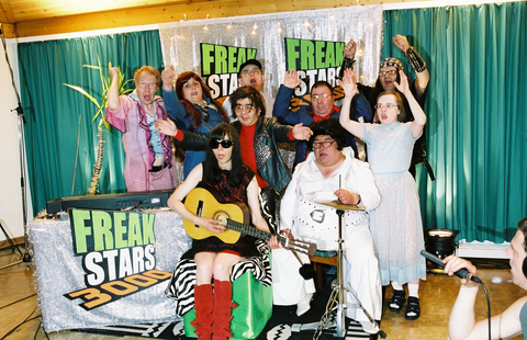 Foto von Christoph Schlingensiefs "Freakstars" - zu sehen eine Gruppe verrückt aussehender Menschen, teilweise mit Instrumenten