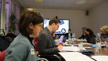 Menschen sitzen in einem Konferenzraum um einen Tisch