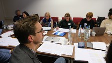 Menschen sitzen in einem Konferenzraum um einen Tisch