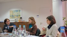 Menschen sitzen in einem Konferenzraum um einen Tisch