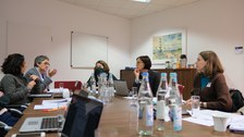 Menschen sitzen in einem Konferenzraum um einen Tisch