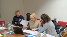Menschen sitzen in einem Konferenzraum um einen Tisch