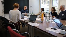 Menschen sitzen um einen Tisch