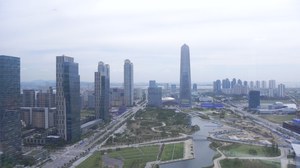 Vogelperspektive der Stadt Songdo. In der Mitte ein Park, darum Hochhäuser