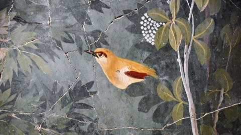 Altes Fresko eines golden leuchtenden Vogels in einem Garten