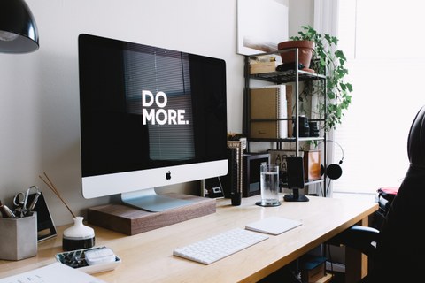 Schreibtisch mit Mac auf dem "Do More" angezeigt wird