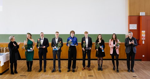 Die sieben ausgezeichneten Studierenden stehen nebeneinander vor eine Tafel. Links von ihnen steht die Rektorin Prof. Dr. Staudinger, ganz rechts der Prorektor Bildung, Prof. Dr, Kobel.