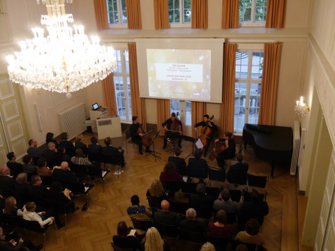 Das Foto zeigt den Blick von oben auf das Publikum und das Celloquartett im Festsaal des Rektorats der TU Dresden anlässlich der Feierlichen Eröffnung des Centrums Frankreich | Frankophonie an der TU Dresden am 16. Mai 2019.