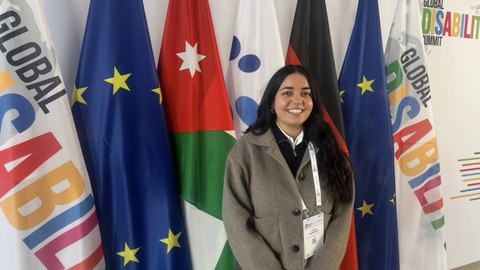 Scherin Wahabzadeh, vor Flaggen stehend