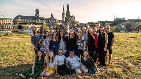 Foto einer Gruppe Studierender auf den Elbwiesen, im Hintergrund die Dresdener Altstadt