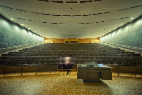 Hörsaal im Hörsaalzentrum der TU Dresden. Im Vordergrund steht das Sprecherpult. Im Hintergrund befinden sich die Bankreihen.
