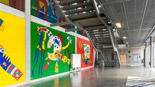 Eingangshalle des Hörsaalzentrums mit farbiger Wandbemalung und großer Treppe