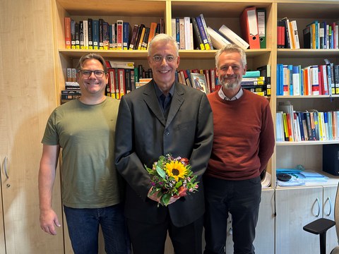 Das Bild zeigt Prof. Christian Leßmann, Stefan Robel und Prof. Alexander Kemnitz vor einer Bücherwand.