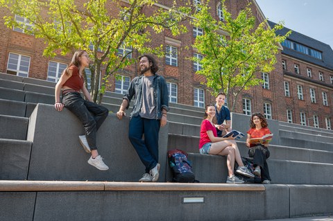 Bild zeigt 5 Studierende, die sich auf den Treppen am Fritz-Foerster-Bau unterhalten und zusammen lernen